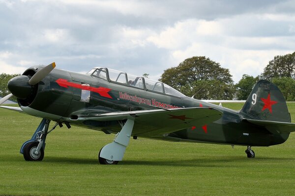 Caza de entrenamiento soviético Yak - 11 en el campo verde