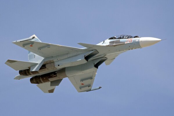 Russian SU flying against the background of a blue cloudless sky