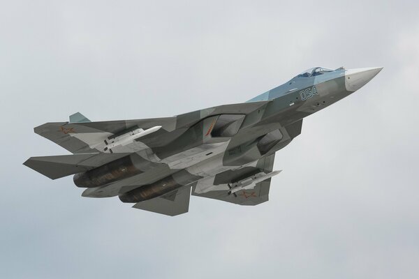 Le chasseur polyvalent t-50 vole dans le ciel blanc et gris