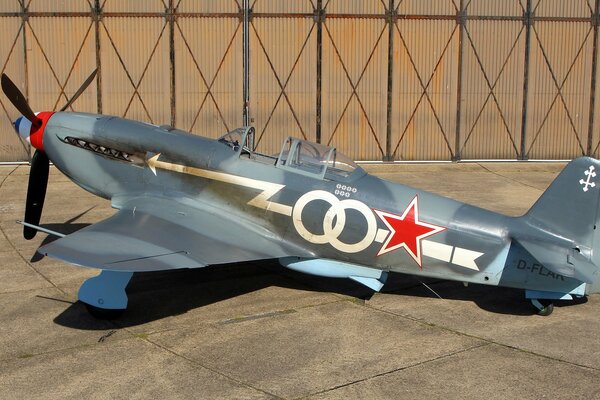 Un combattente sovietico dipinto Yak-3 si trova in un hangar