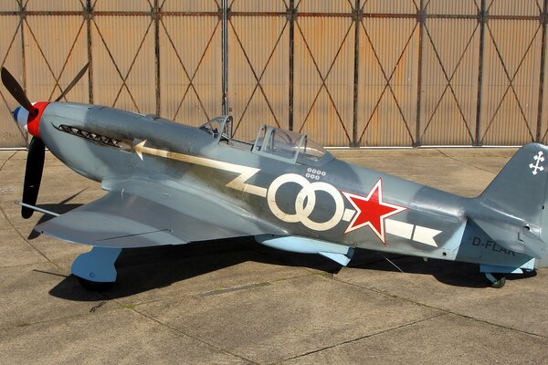 Pomalowany radziecki myśliwiec Jak-3 stoi w hangarze