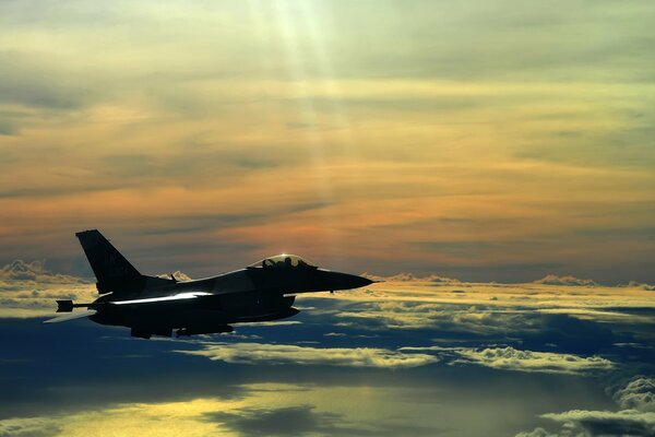 Combattant militaire parmi les nuages au coucher du soleil