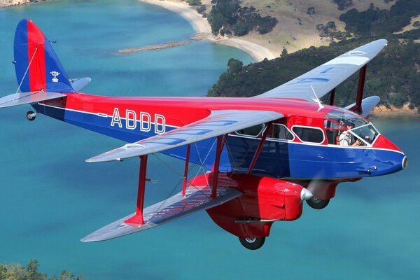 Ein schönes und helles Flugzeug fliegt über das Meer