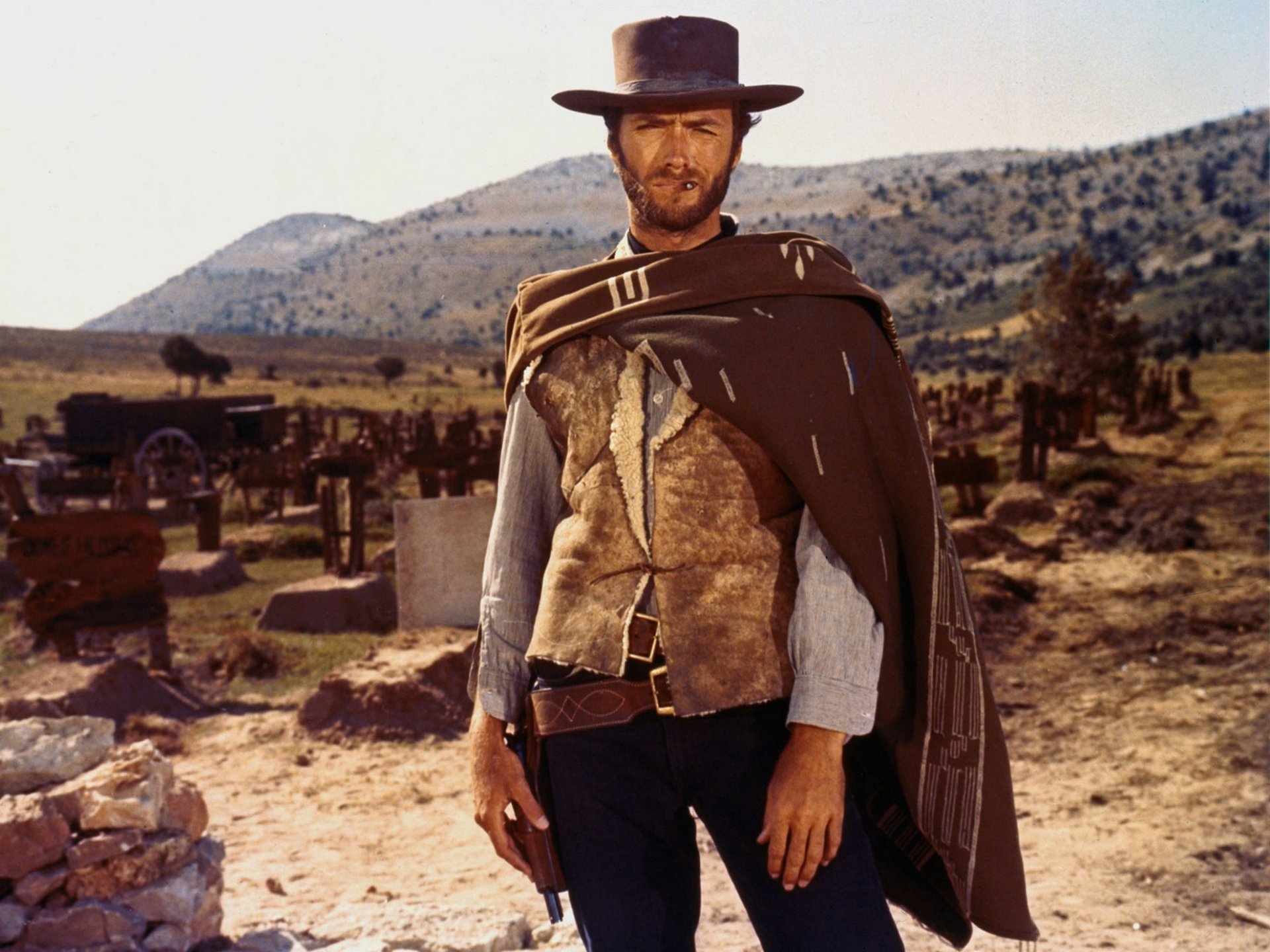 clint eastwood bien ouest sauvage manteau pistolet cimetière tombe acteur western bon mauvais en colère colline trésor arme revolver