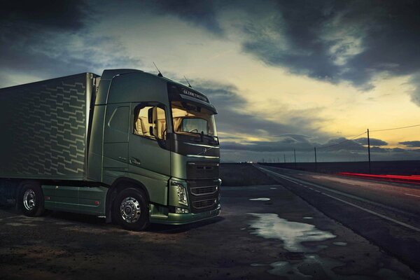 Highway with a truck with a trailer on the background of the sky