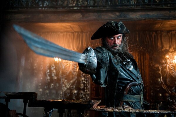 Pirates of the Caribbean. Blackbeard points with a saber. On the background of skeletons