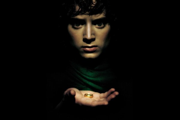 Frodo sostiene un anillo en sus Palmas