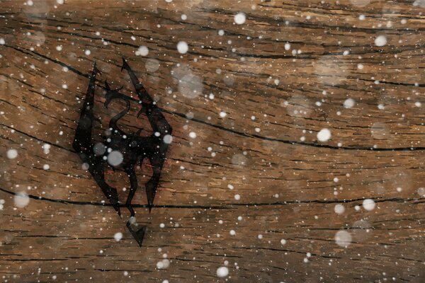 Logo del gioco per computer Skyrim stampato sulla superficie del legno