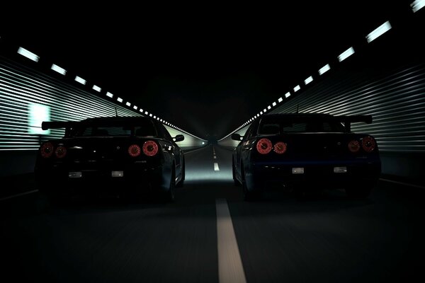 Dos coches negros circulan por la carretera nocturna