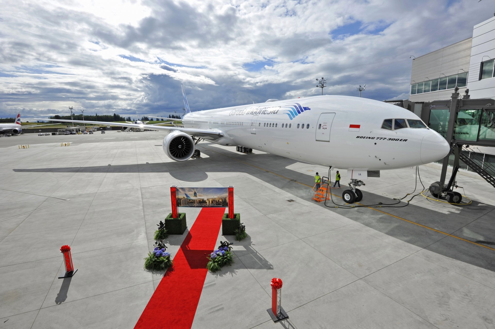 garuda indonesia boeing er avión avión de pasajeros alas motor aeropuerto terminal plataforma tiempo cielo nubes rojo pista avión pasajero terminal del aeropuerto delantal rojo