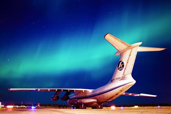 IL-76 military transport aircraft at night in the shining sky