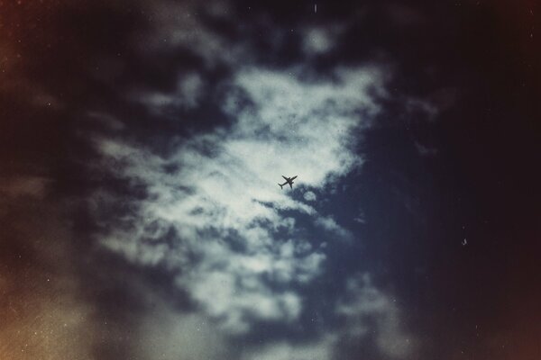Samolot wysoko na niebie wśród chmur