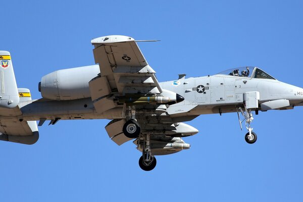 Военный самолёт с боекомплектом на фоне голубого неба