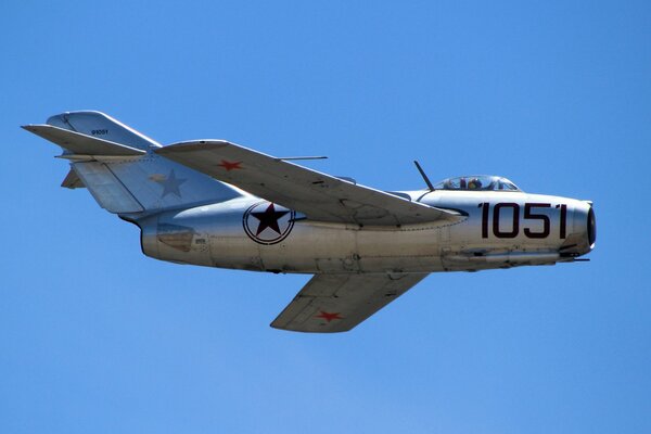 The flight of the Soviet MIG-15 fighter against the blue sky