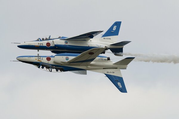 Two planes perform a dangerous stunt in the sky