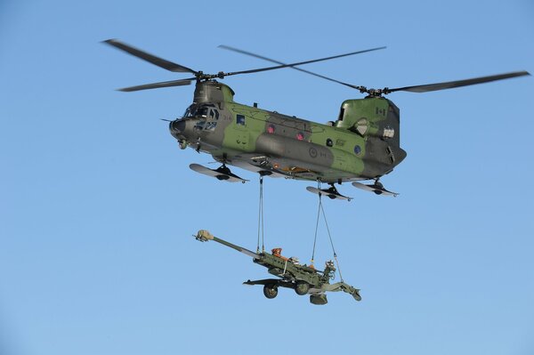 Avión de transporte militar en el cielo que transporta un obús