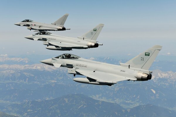 Eine Gruppe von Kampfjets fliegt über die Berge am Himmel