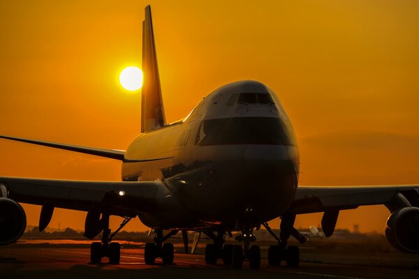 Aereo passeggeri Boeing 747a sullo sfondo del tramonto