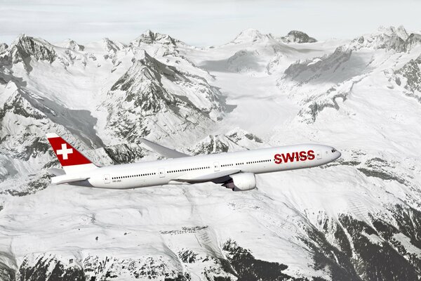 Passagierflugzeug fliegt über schneebedeckte Berge
