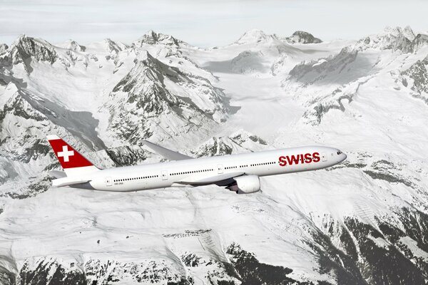 Passenger plane flies over snowy mountains