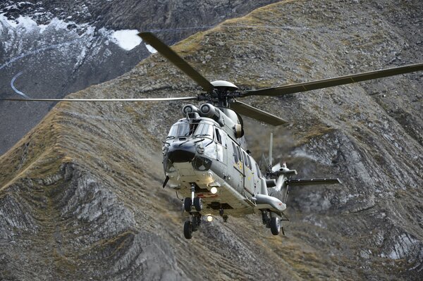 Ein Mehrzweckhubschrauber von Puma fliegt über die Berge