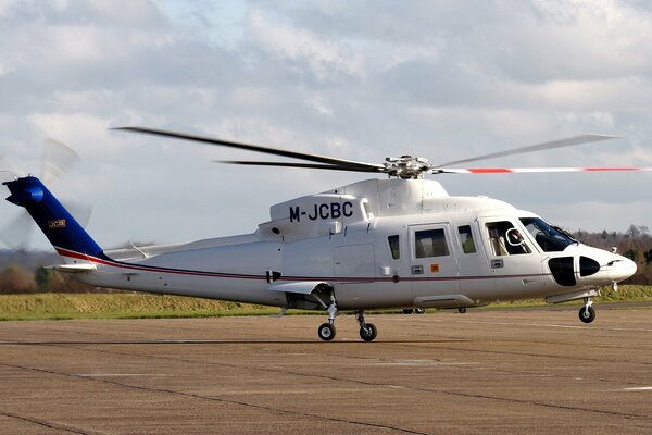 Взлетающий вертолёт сикорский. s- 76 с вертолётной площадке