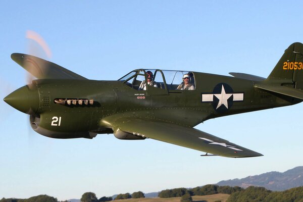 A plane flying in the air with two pilots