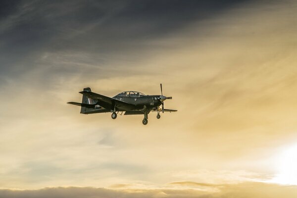 Das Flugzeug fliegt im Hintergrund des Sonnenuntergangs