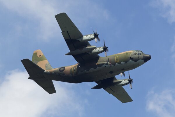 A military transport plane hovers over the city