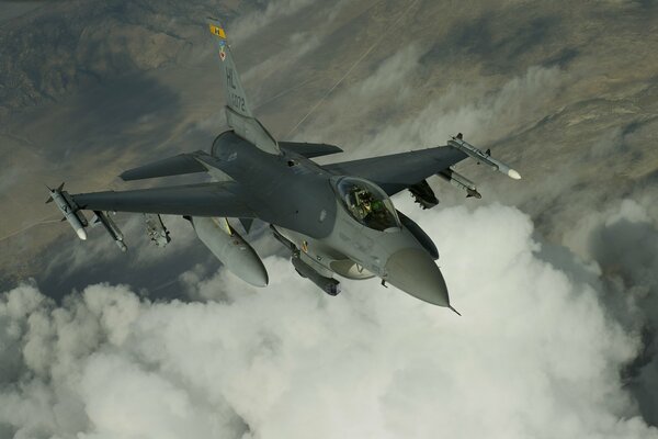 Fliegender Kampfjet über weißen Wolken