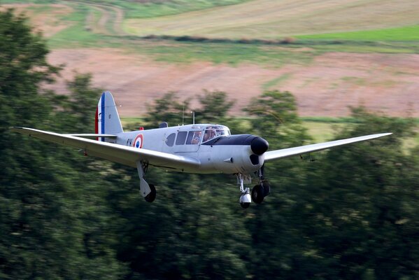 A small plane in flight above the ground