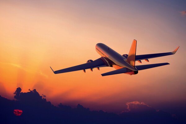 Un avión vuela en el cielo al amanecer