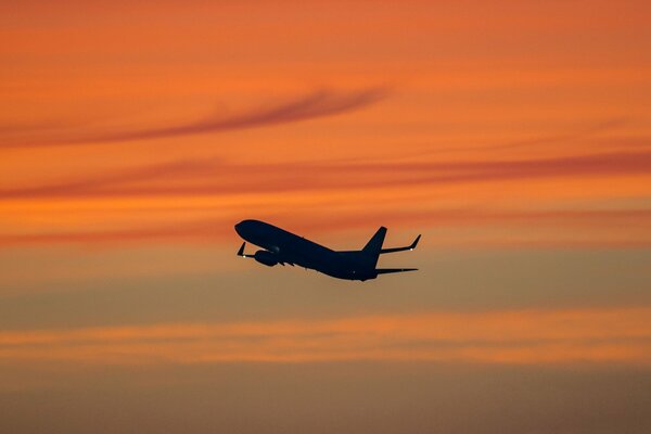 Passenger plane in the sky at sunset