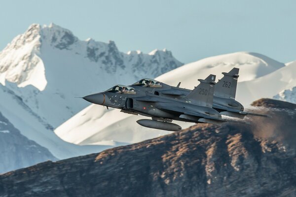 Das Flugzeug fliegt vor dem Hintergrund der schneebedeckten Felsen