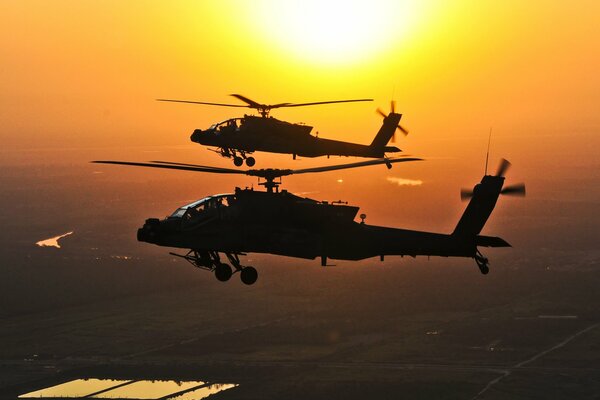 Eine Gruppe von zwei Apache fliegen vor dem Hintergrund der Sonne