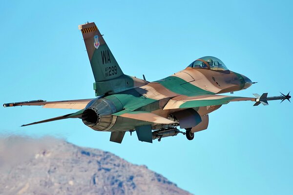Un chasseur militaire F16 survole les montagnes