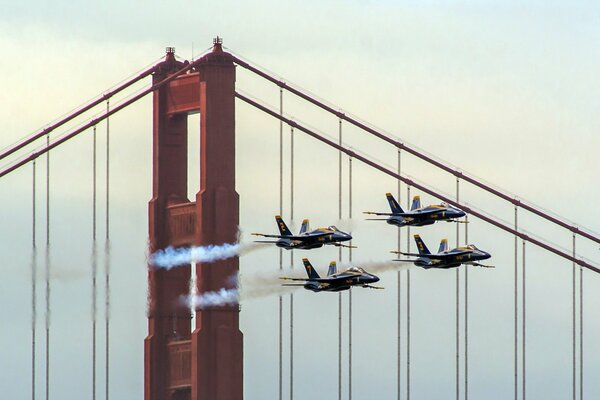 Blaue Flugzeuge fliegen über eine große Brücke