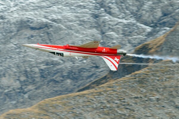 White-red plane on the background of a mountain range