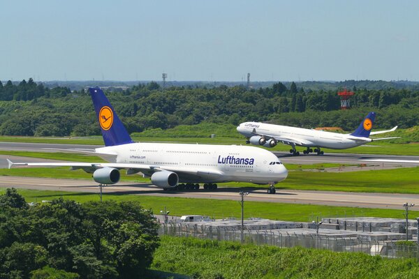 Two white planes are standing on the runway