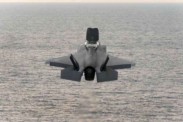 Fighter bomber takes off over the sea