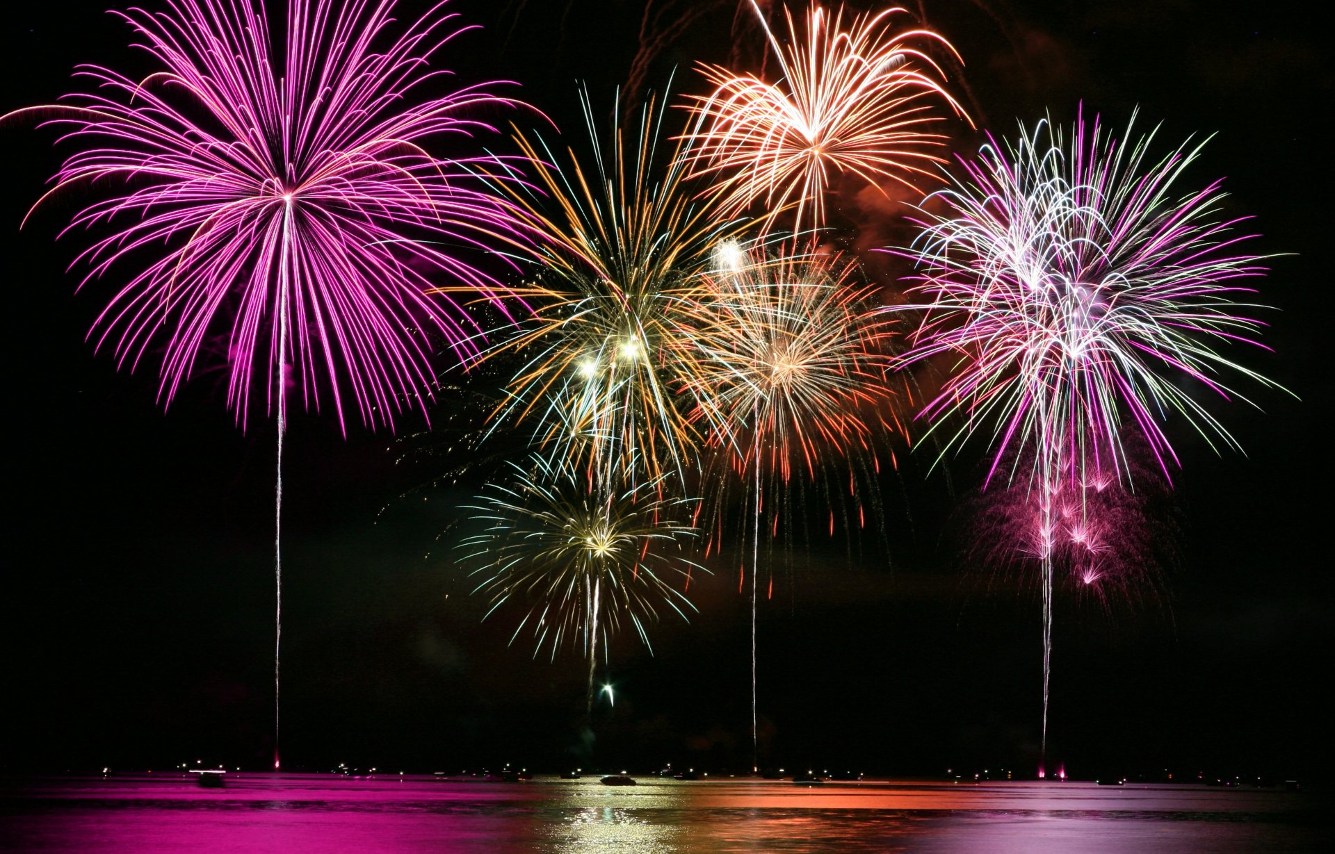 fireworks salute night water reflection sky light lights town