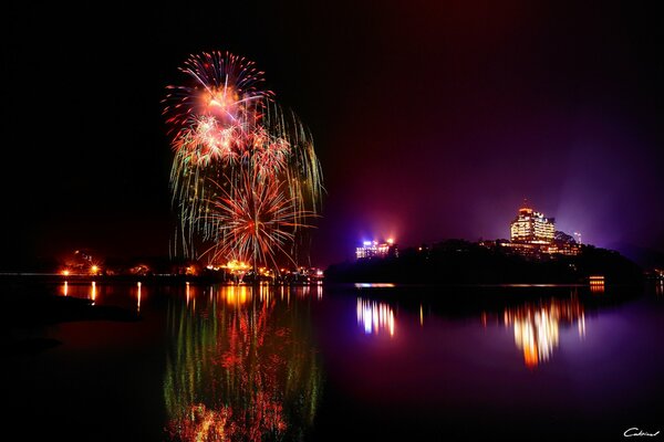 Festive fireworks over the water surface of the lake