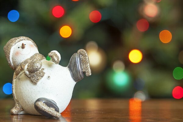 Muñeco de nieve de juguete de Navidad en el fondo del árbol de Navidad decorado