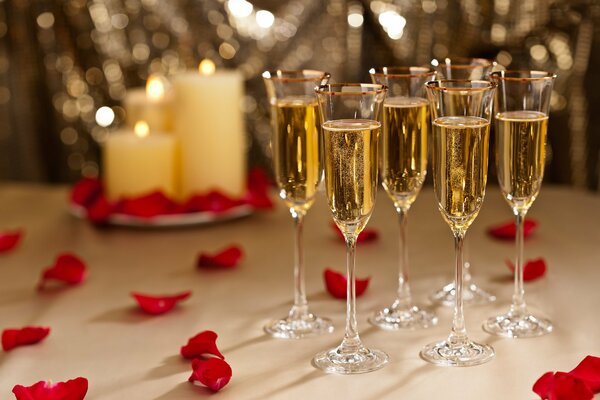 Five glasses of champagne with rose petals