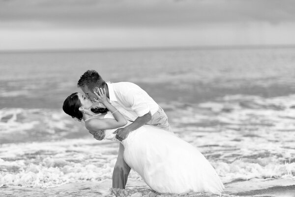 Doux baiser de la mariée et le marié au bord de la mer