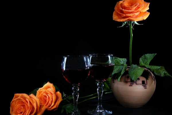 Orange Rose im Topf und zwei Gläser mit Wein