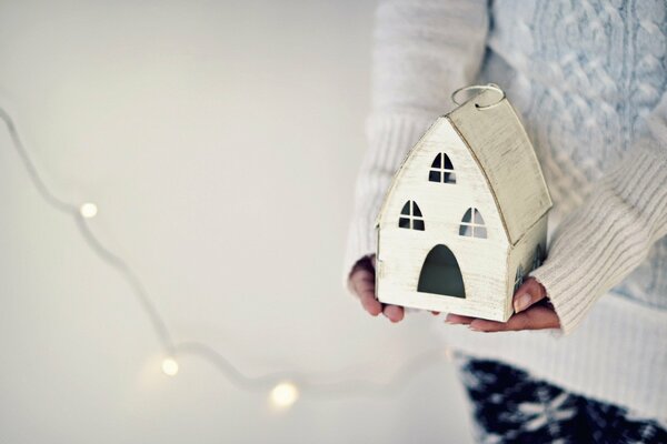 A toy house in the hands of a girl