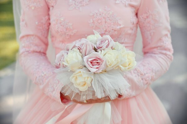 Mädchen in einem rosa Kleid mit einem Blumenstrauß