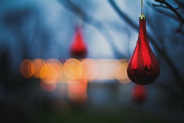 Jouet de sapin rouge sur fond de lumières