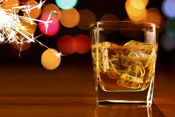 Dans un verre de whisky glace à côté de lui étincelles